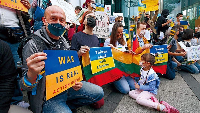 烏克蘭爆發戰事，在台外國人與台灣民眾於台北街頭發起聲援行動,他們舉著「台灣與烏克蘭站在一起」的牌示，呼籲停止戰爭